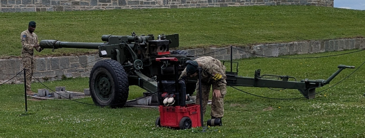 Soldiers preparing to shoot a cannon at noon
